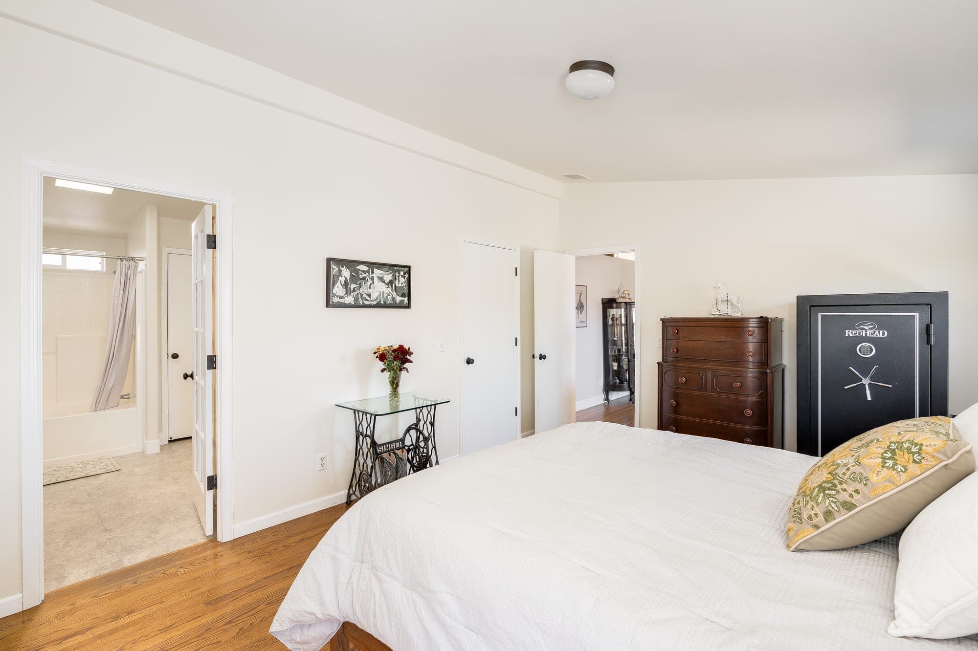A bedroom with a door to an adjoining bathroom.