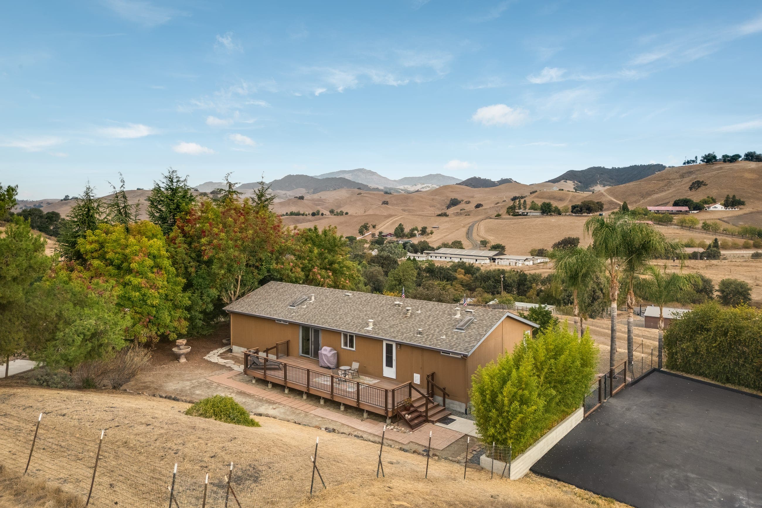The residence's rear deck from above, looking out over the valley and ridgelines.
