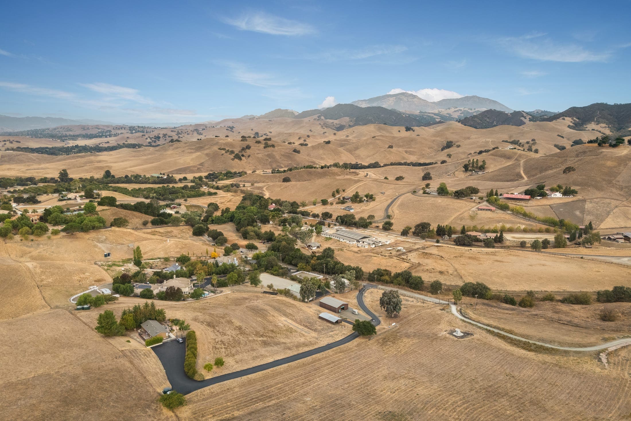 Aerial view across the valley toward distant peaks.