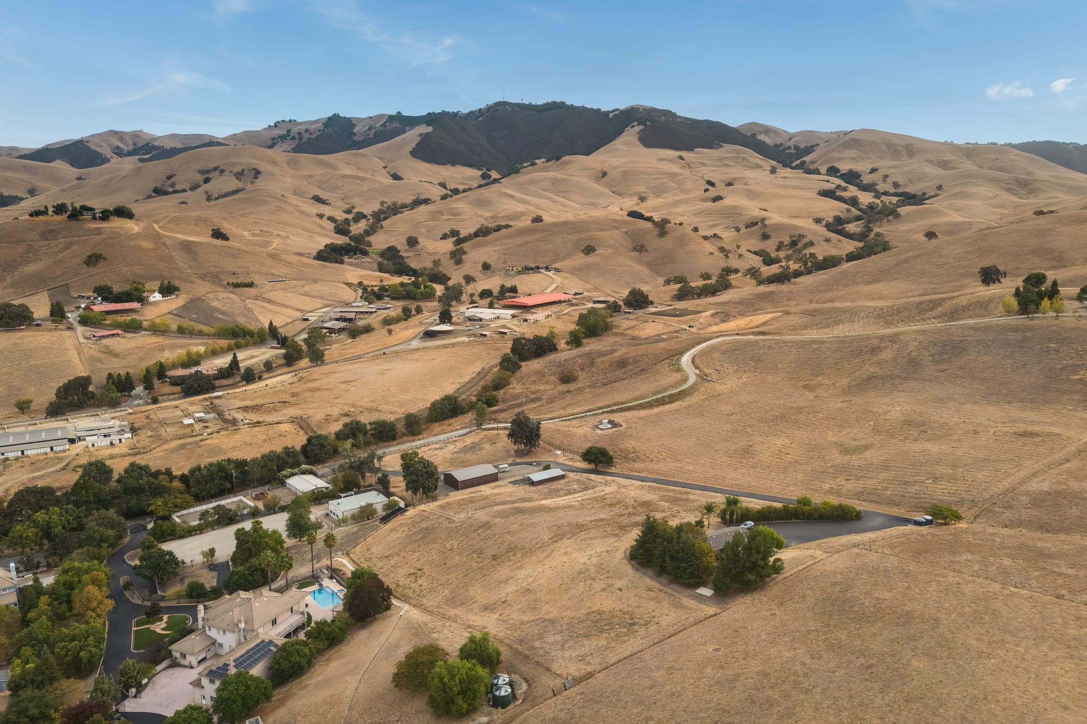Aerial view of the Tassajara Valley: open hillsides, scattered homes, and ridgelines.