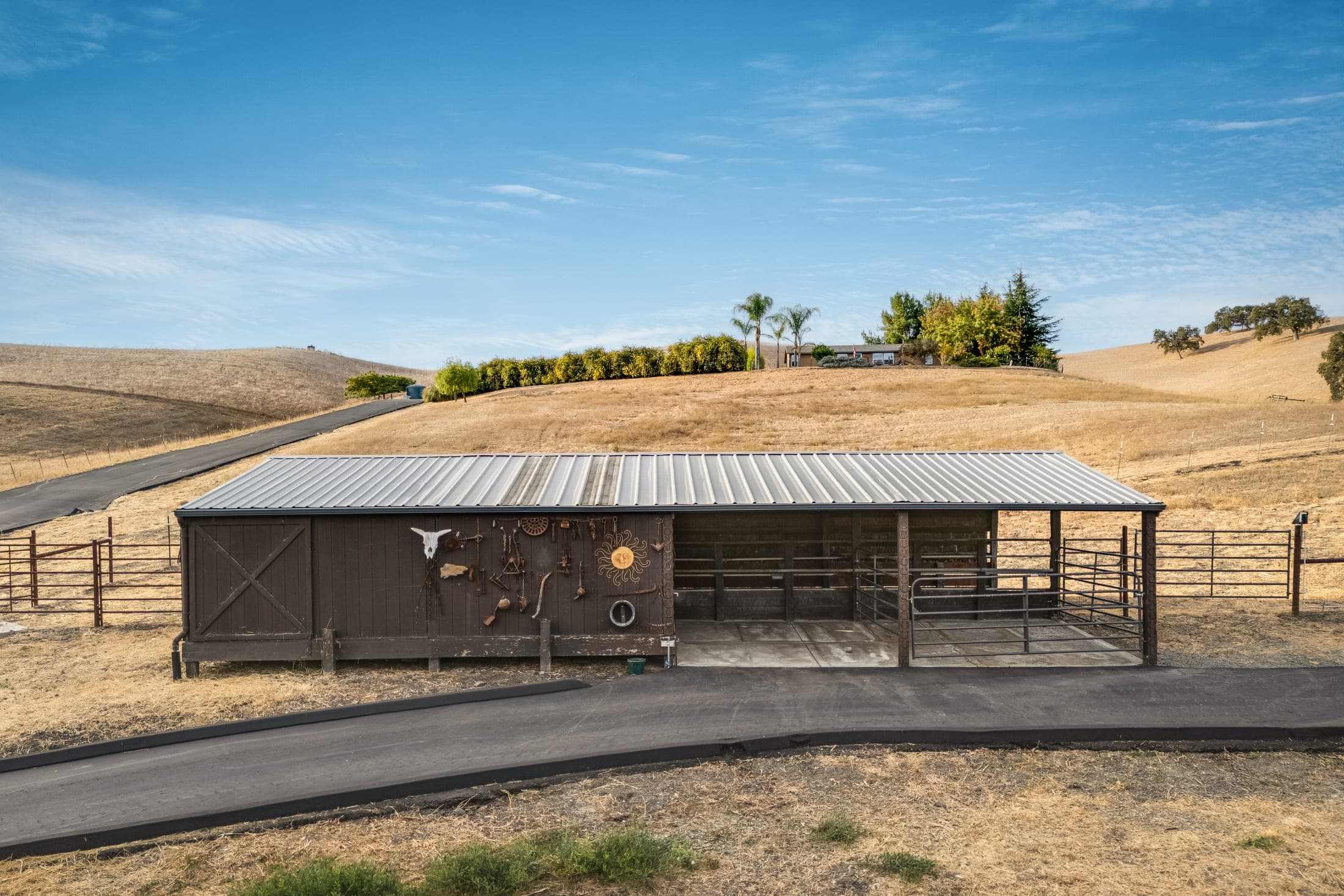 The covered barn with pipe-panel fencing.